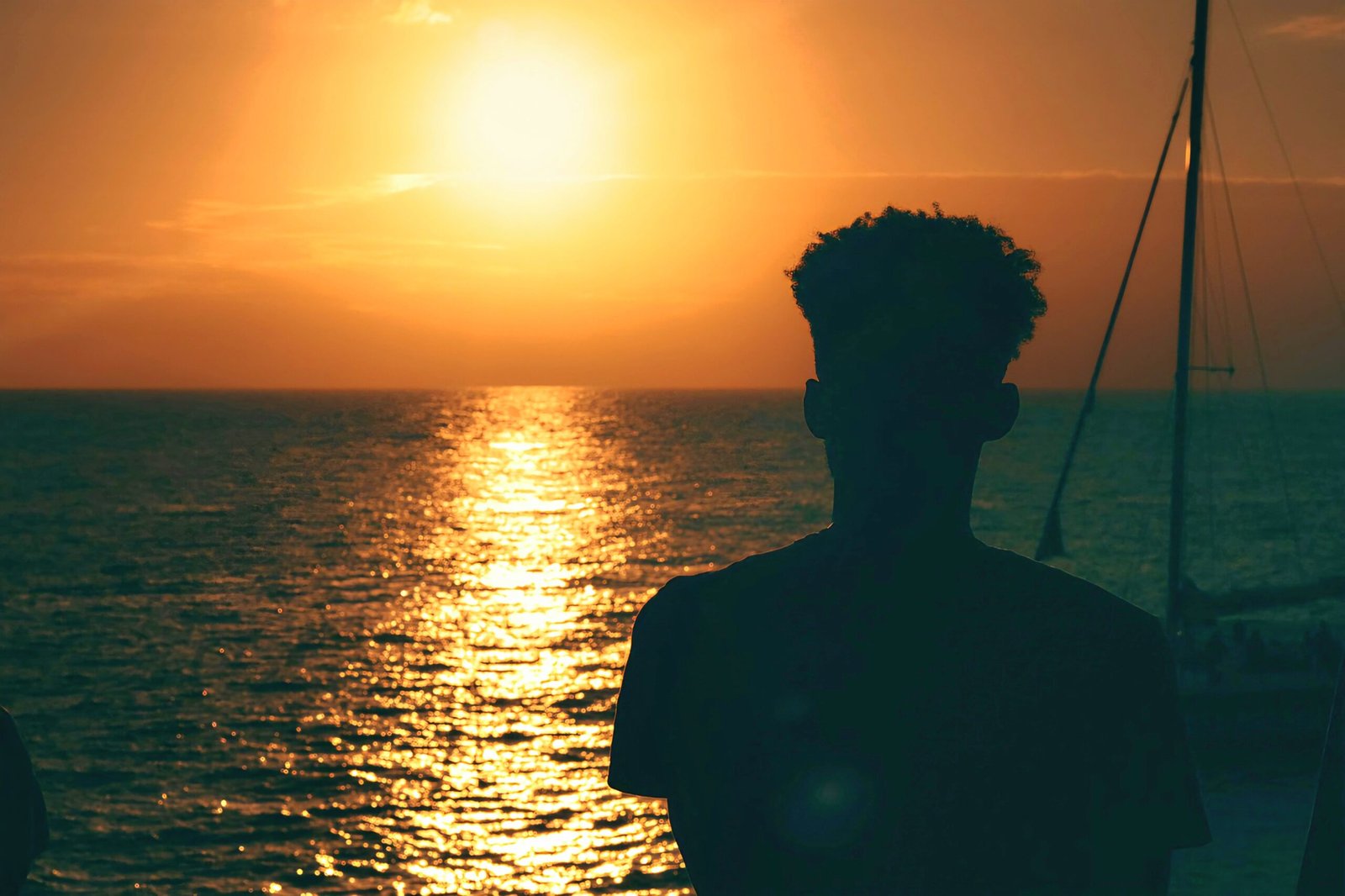 Jamaica The Caribbean & The World Needs To Go Green Photo Of Young Staring Out To Sea As The Sun Sets.