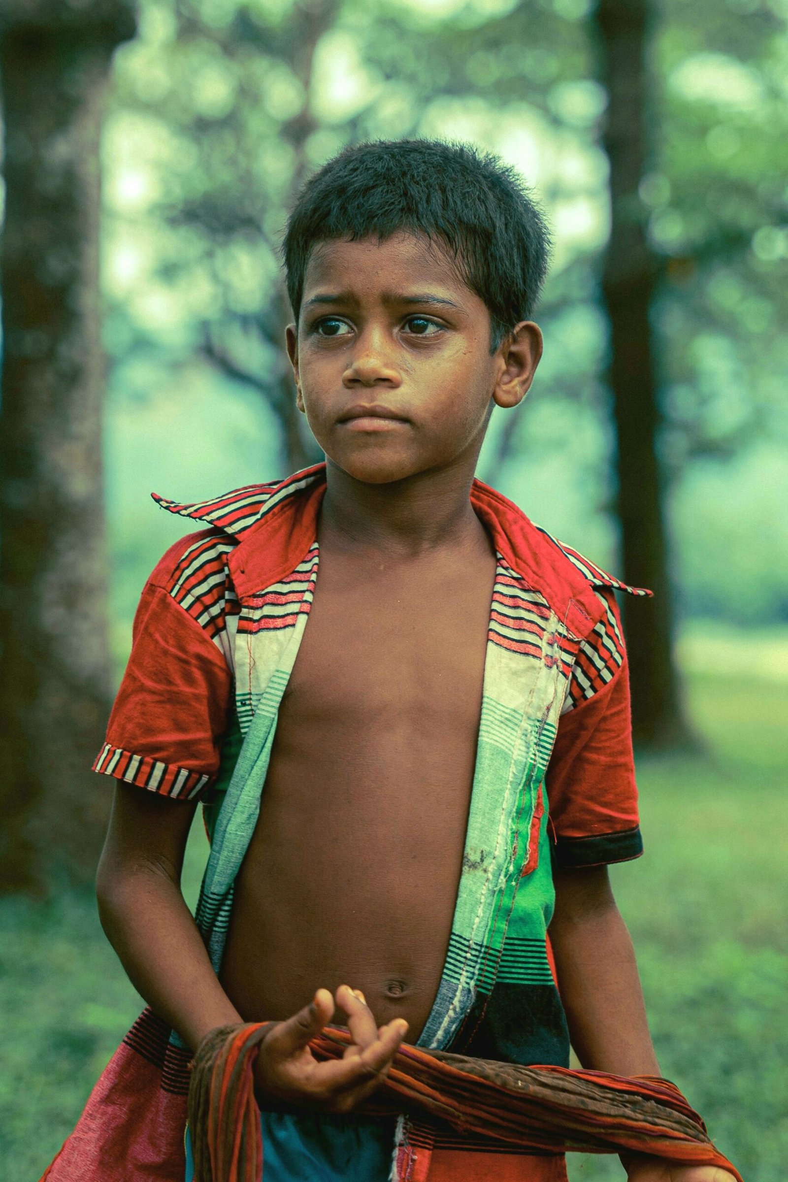 Caricom Climate Change Young Boy in rainforest with apprehensive look on his face