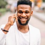 An Update On All Things Island Love WI - pictured is a young man on his phone.